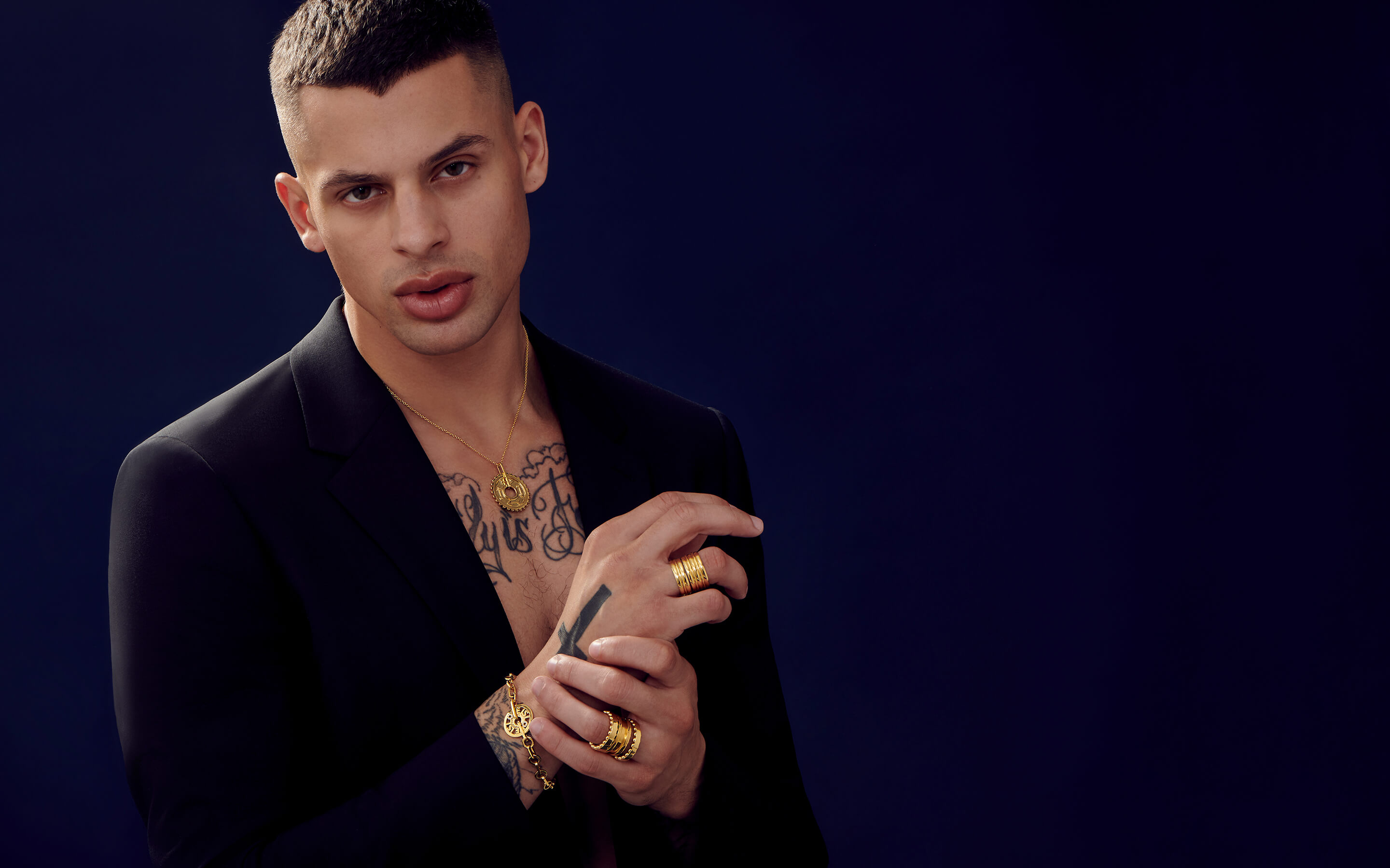 Male model wearing Auvere 22 and 24 karat gold jewelry from the Gold Complex campaign
