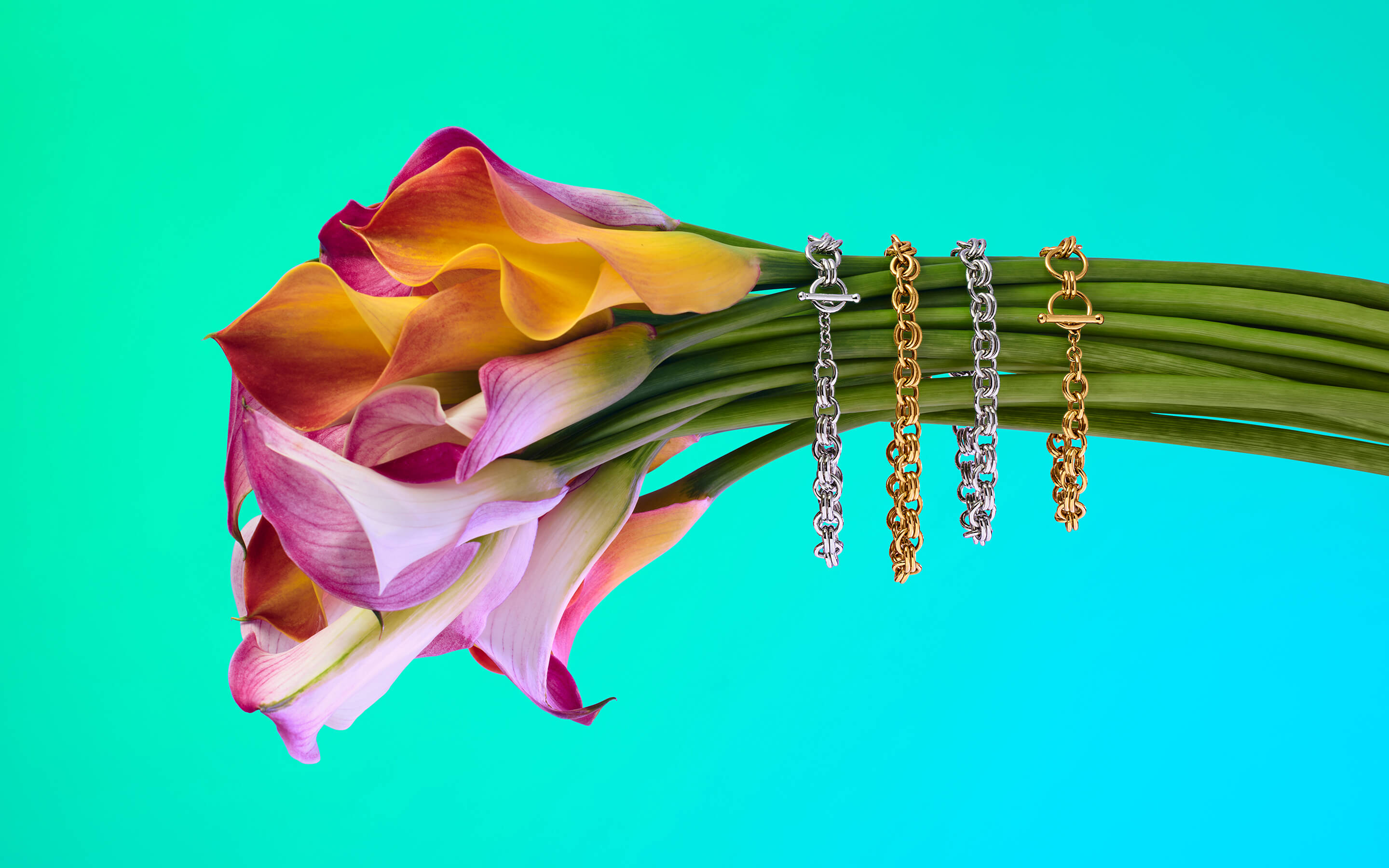 Sterling silver and gold bracelets on a colorful flower