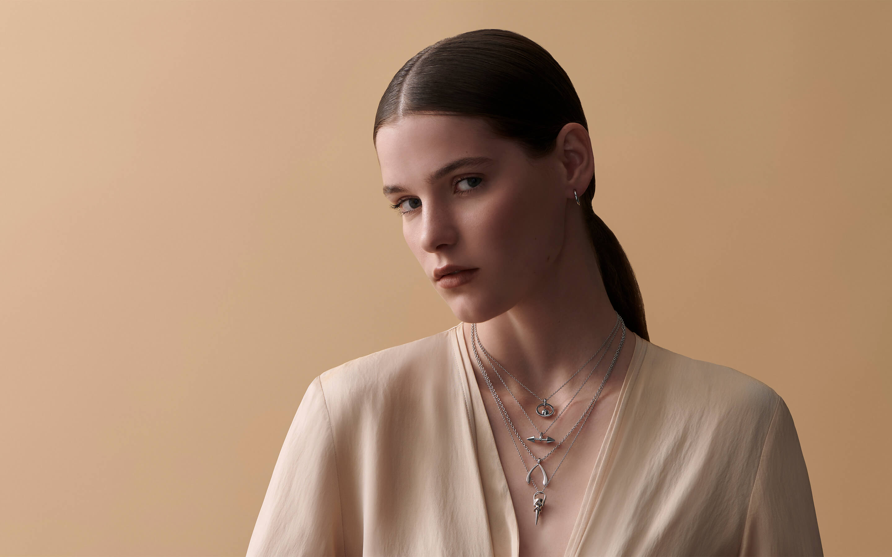 Female model wearing Auvere sterling silver necklaces and earrings
